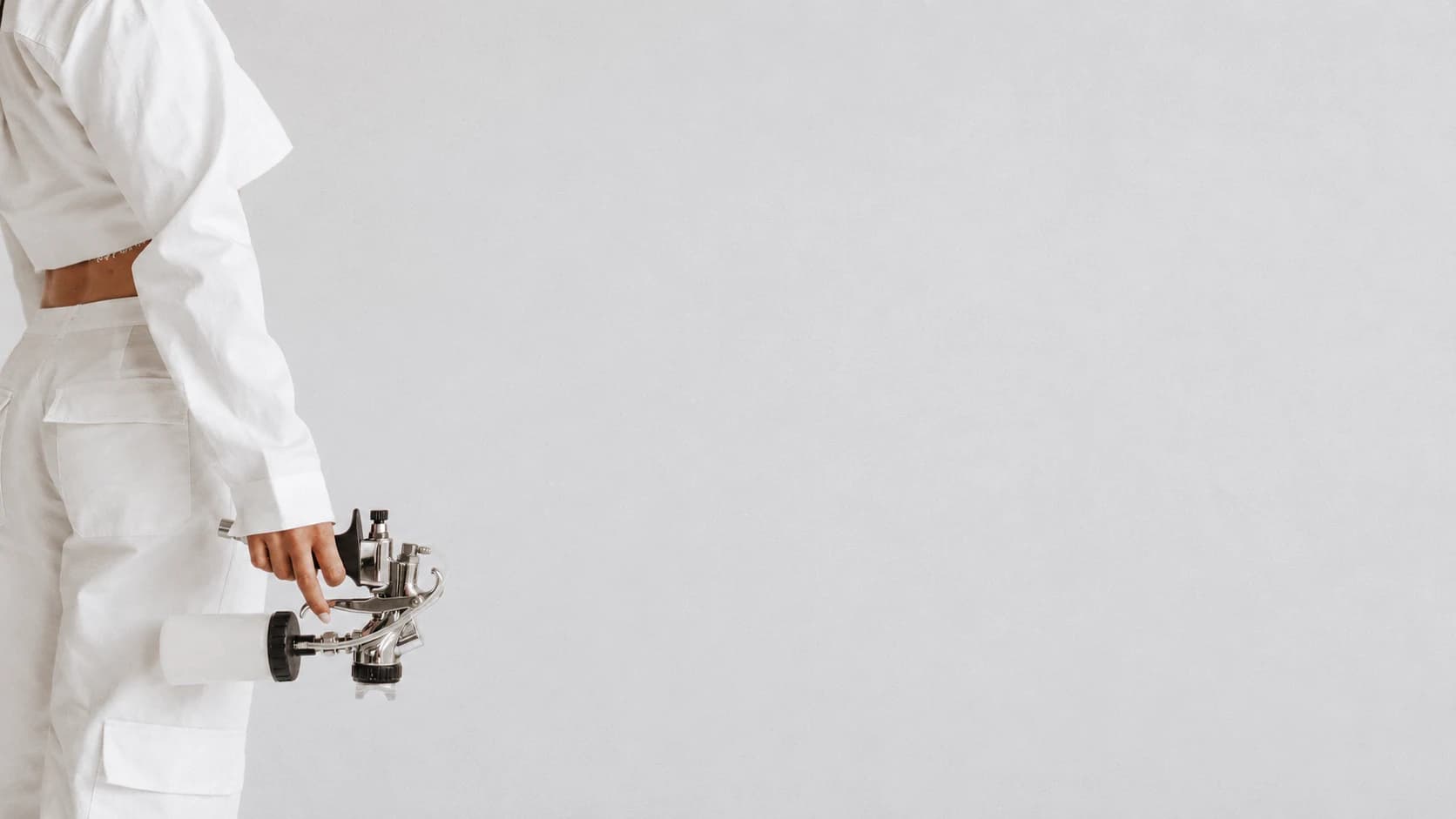 Spray tan artist holding her spray gun