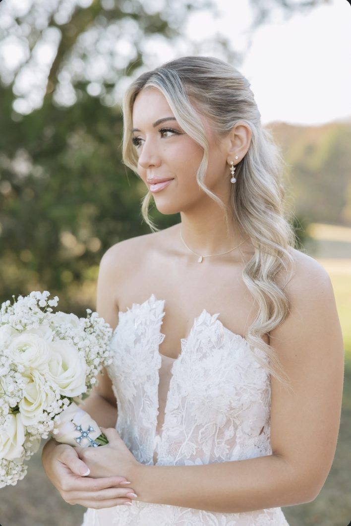 Sister Sunless bride in a lace wedding gown holding a white rose bouquet